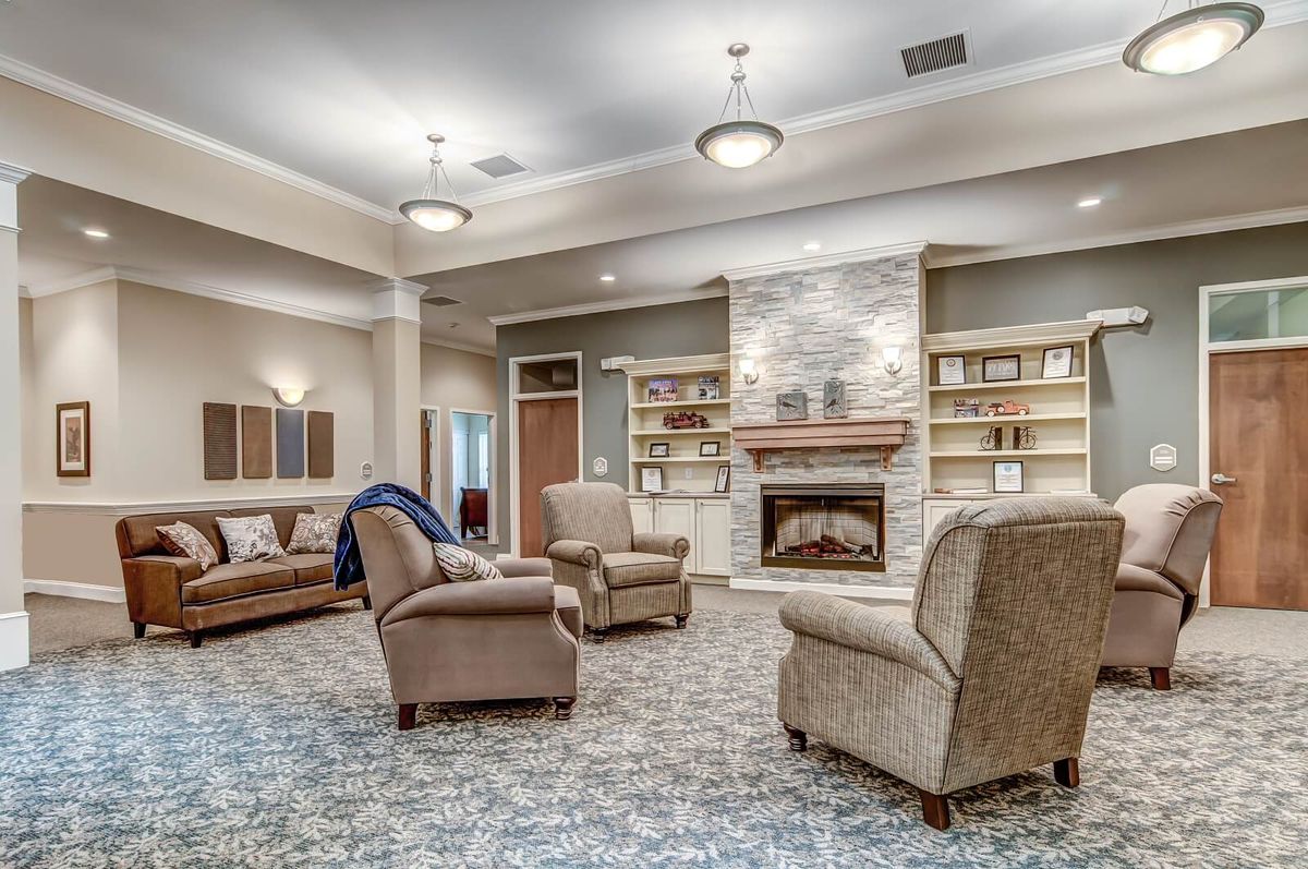A cozy living room with comfortable seating around a fireplace and built-in bookshelves.