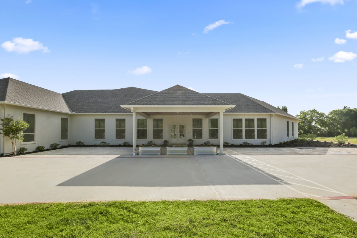 A single-story residential house with a driveway and front yard.