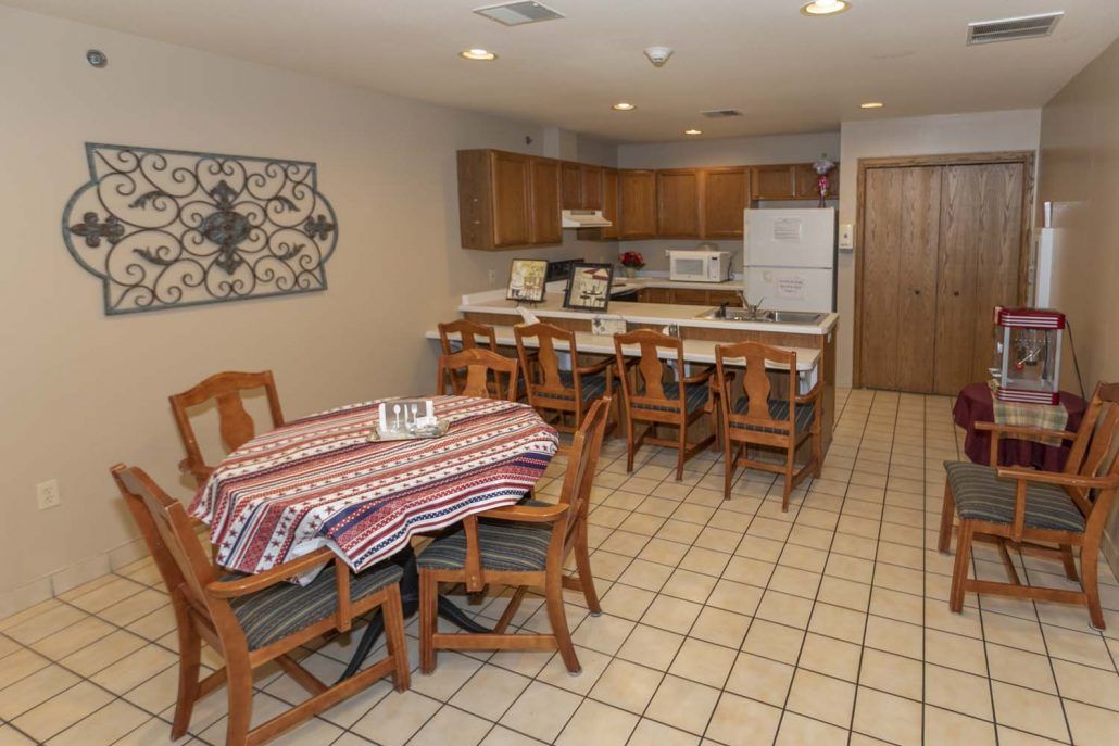 A cozy kitchen and dining area with a wooden table, chairs, and traditional appliances.