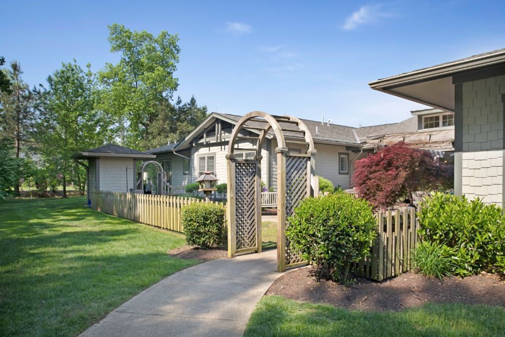 A charming residential home with a welcoming archway and well-maintained garden.