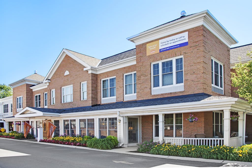 A brick commercial building with multiple windows and a landscaped entrance.