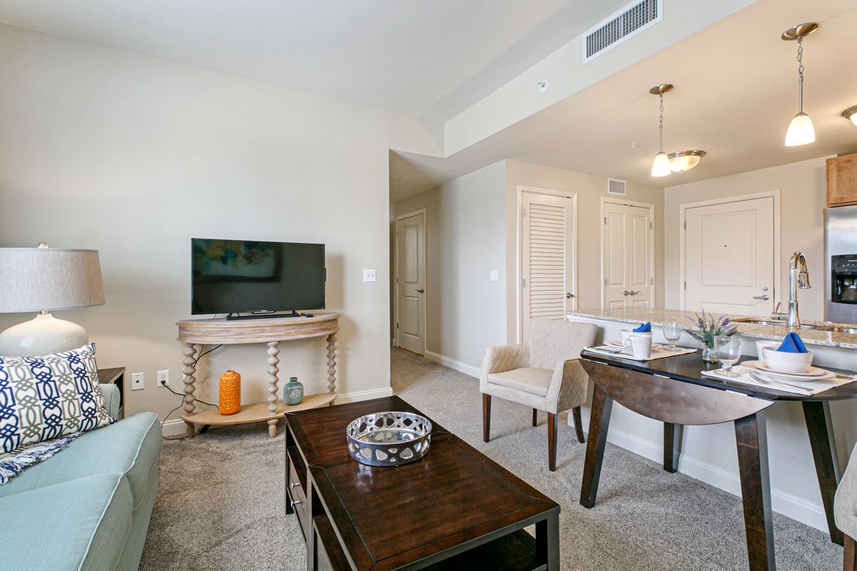 A modern living room with a television, coffee table, and seating area.