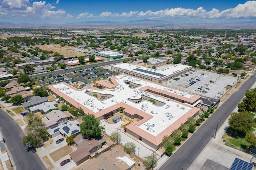 An aerial view of a community building surrounded by residential areas and commercial spaces.