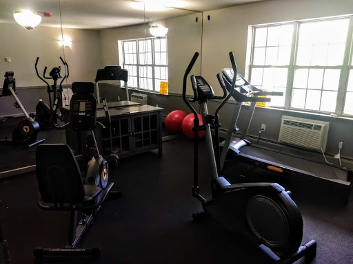 A well-equipped fitness room featuring various exercise machines and free weights.