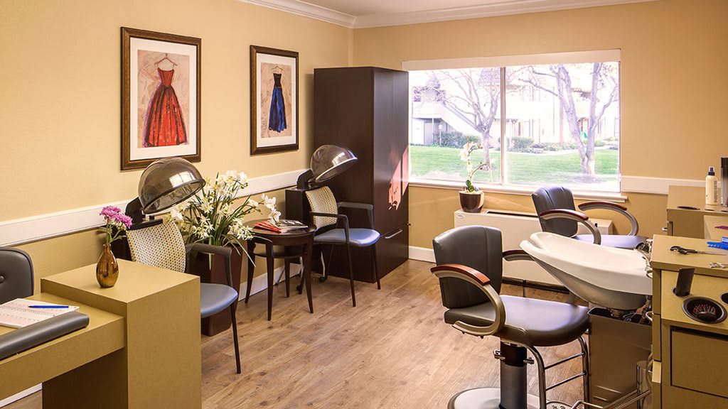 A well-lit salon interior with stylish chairs and hair styling equipment.
