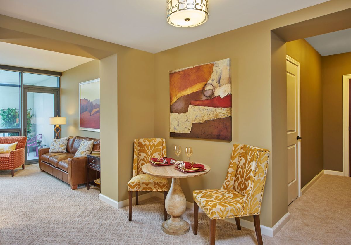 A cozy living room and dining area featuring elegant furniture and vibrant artwork.