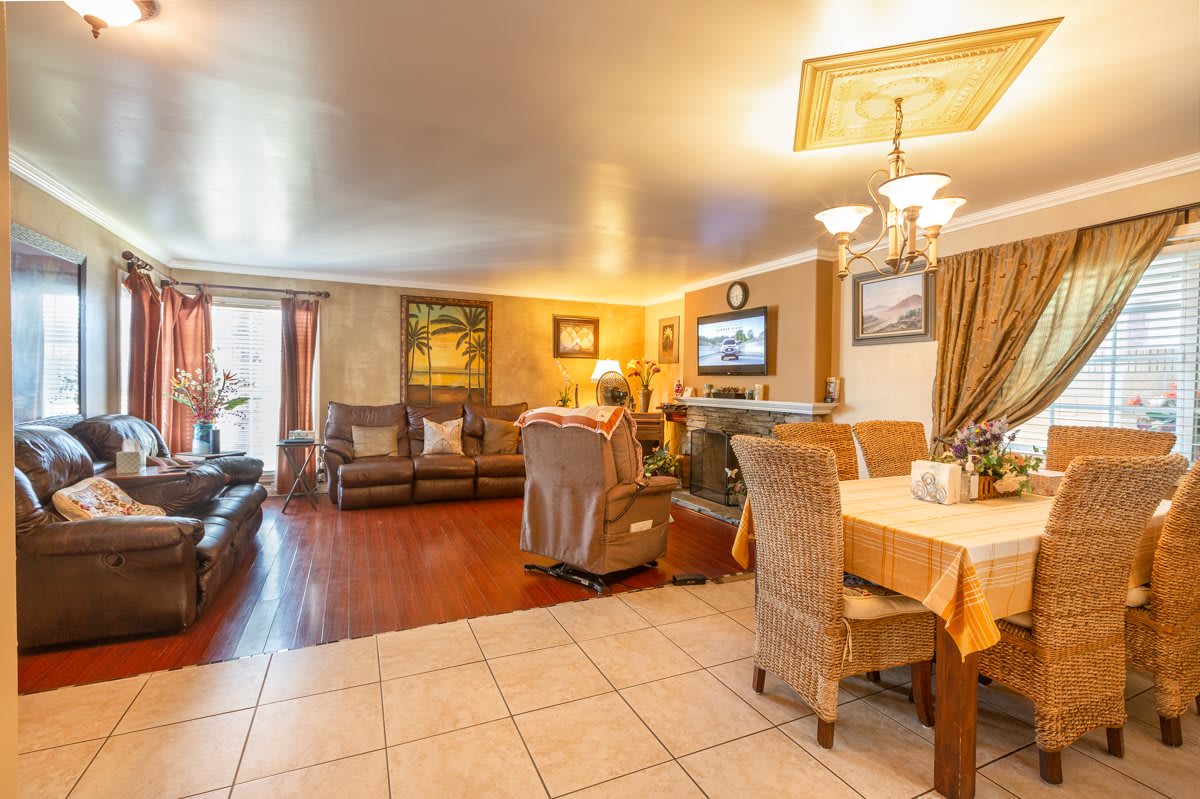 A cozy living and dining space with comfortable seating, warm lighting, and a television.