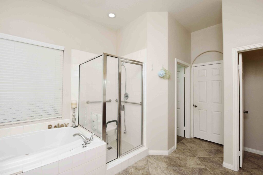 A modern bathroom with a glass shower enclosure and a separate bathtub.