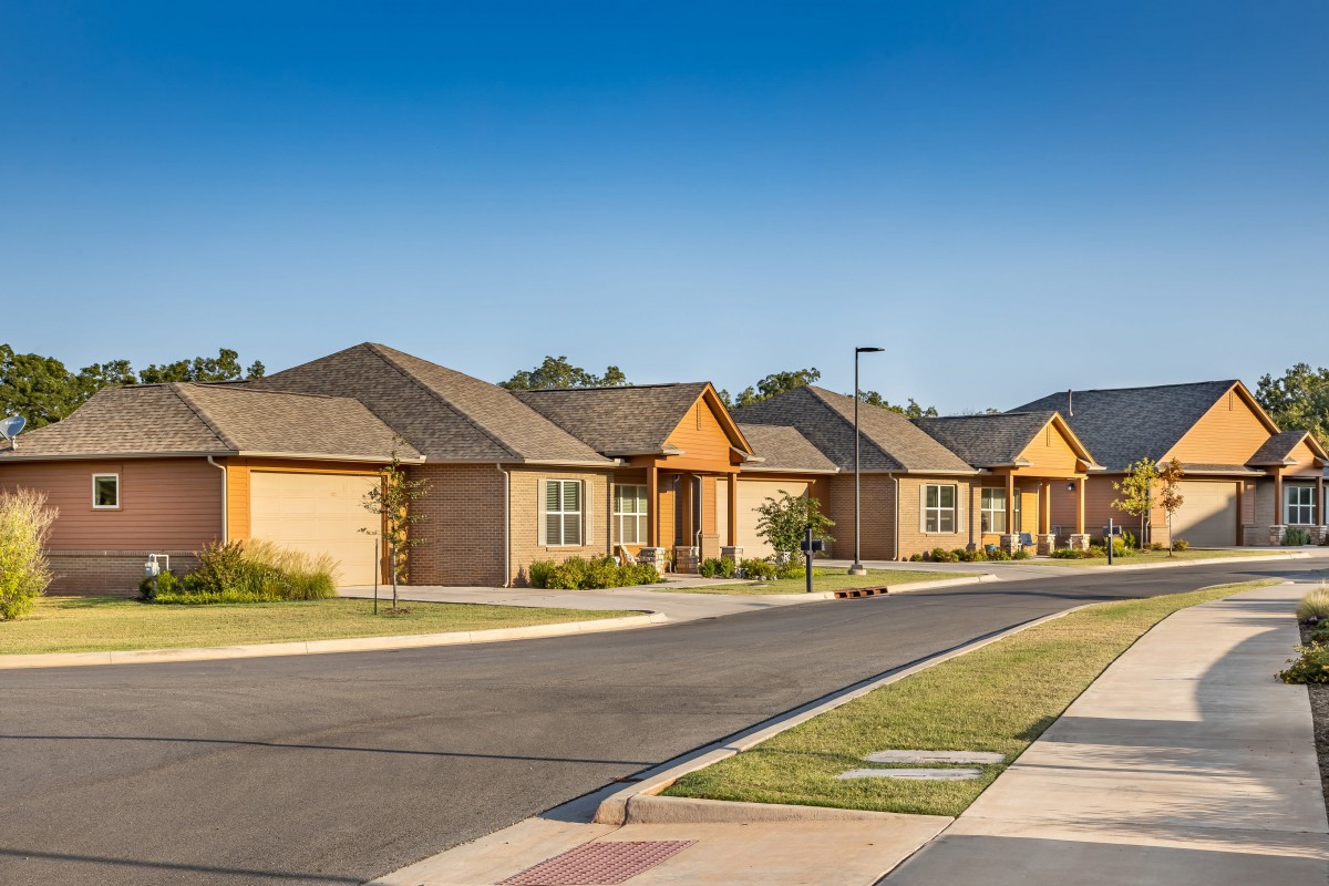 A quiet suburban street lined with modern single-story houses.