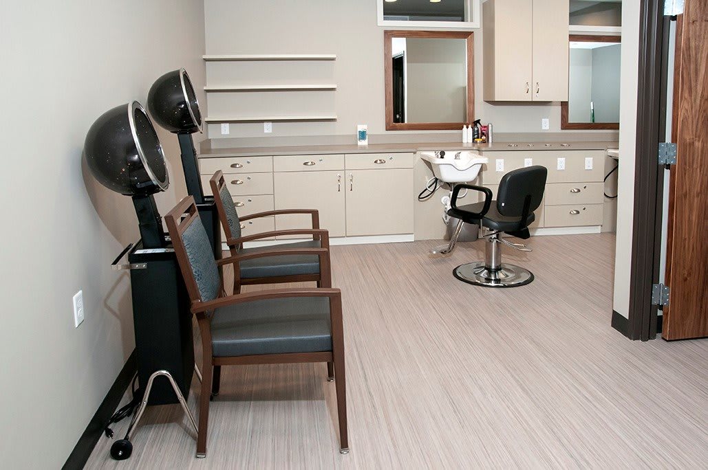 Empty hair salon with styling and dryer chairs.