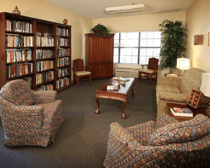 A cozy library reading room with comfortable seating and bookshelves.