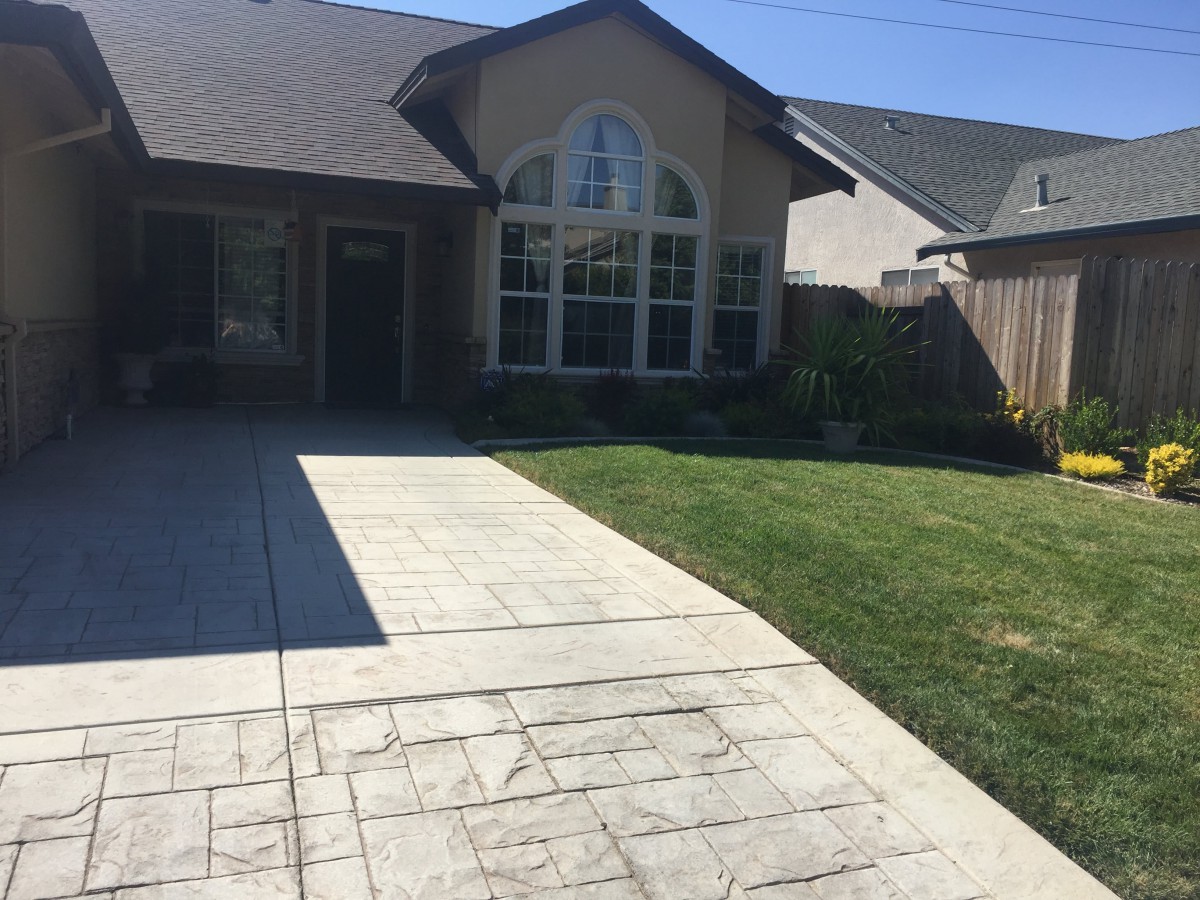 A suburban house with a driveway and well-maintained lawn.
