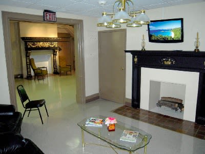A cozy lobby area with a fireplace, television, and seating.