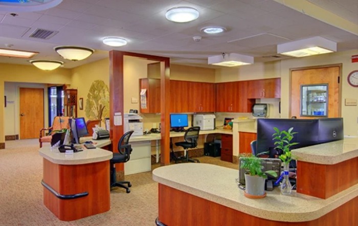 Modern office reception area with desks and computers.