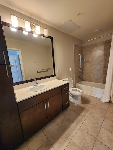 A modern bathroom featuring a stylish vanity with a large mirror and well-lit fixtures.