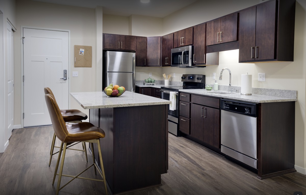 A modern kitchen with stainless steel appliances and a central island.