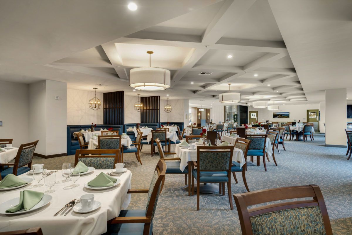 A spacious and elegantly designed restaurant dining area with neatly arranged tables and chairs.