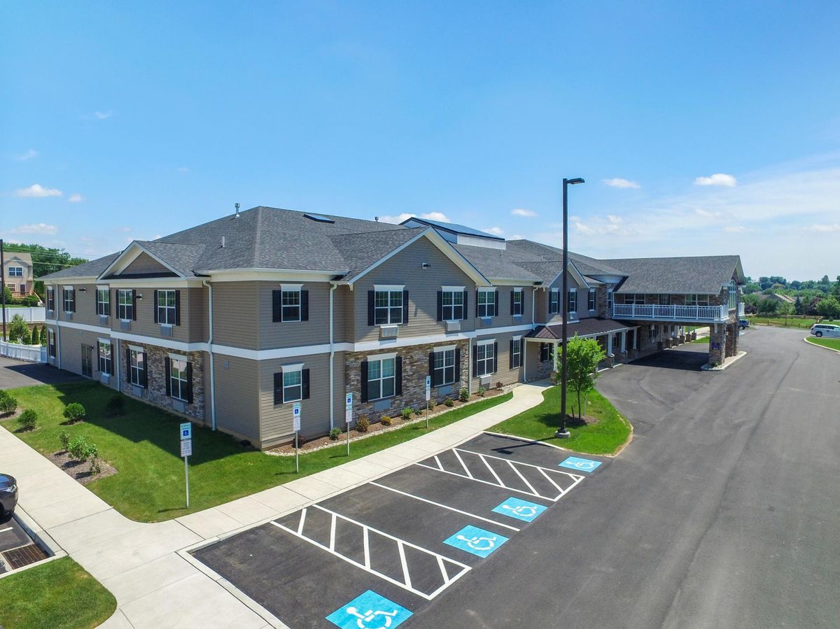 A modern building with a parking lot and clear blue sky.