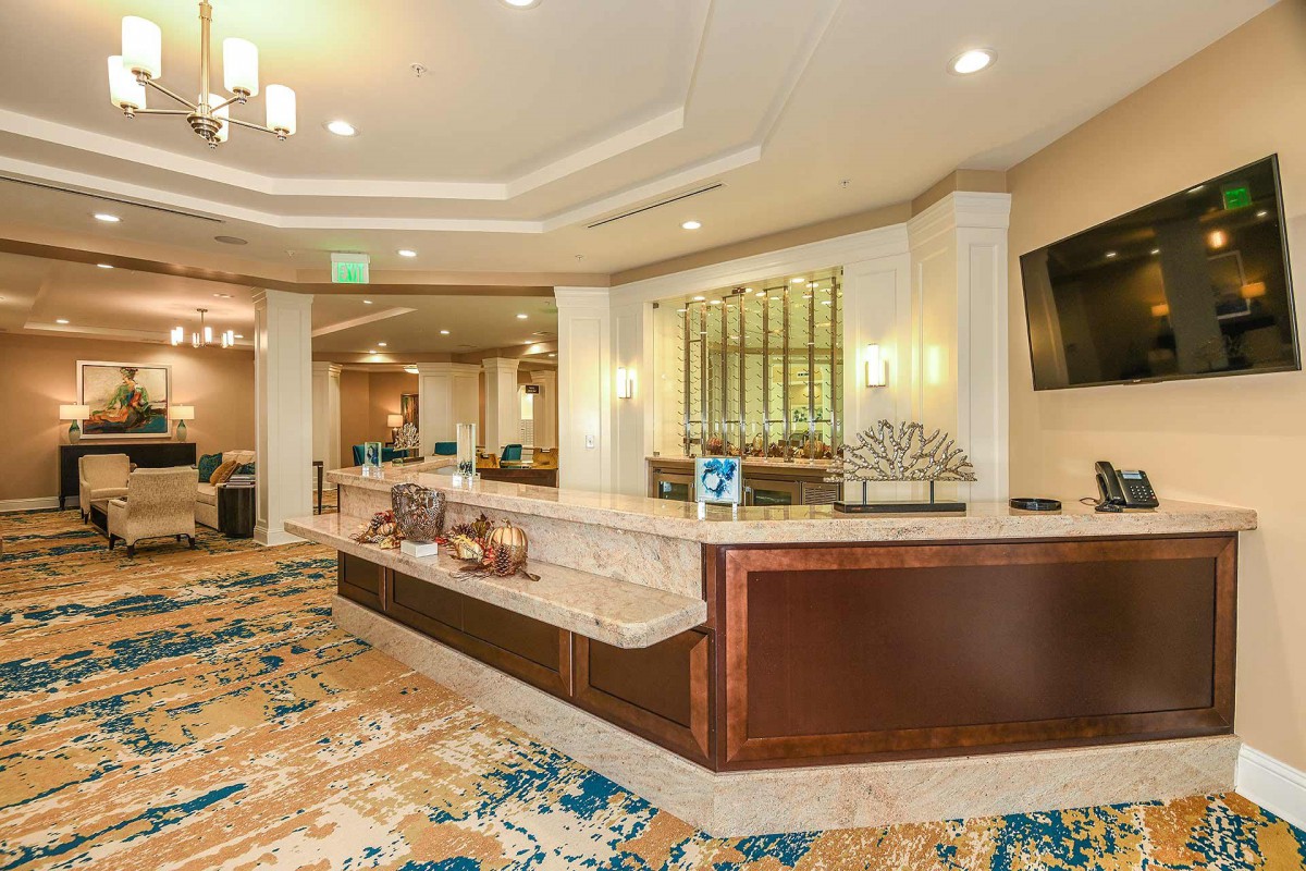 A spacious and well-lit hotel lobby with a reception desk and elegant interior design.