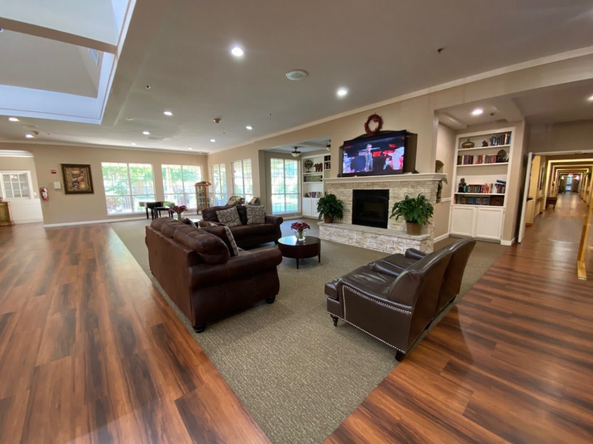 A spacious and well-lit living room with comfortable seating and a fireplace.