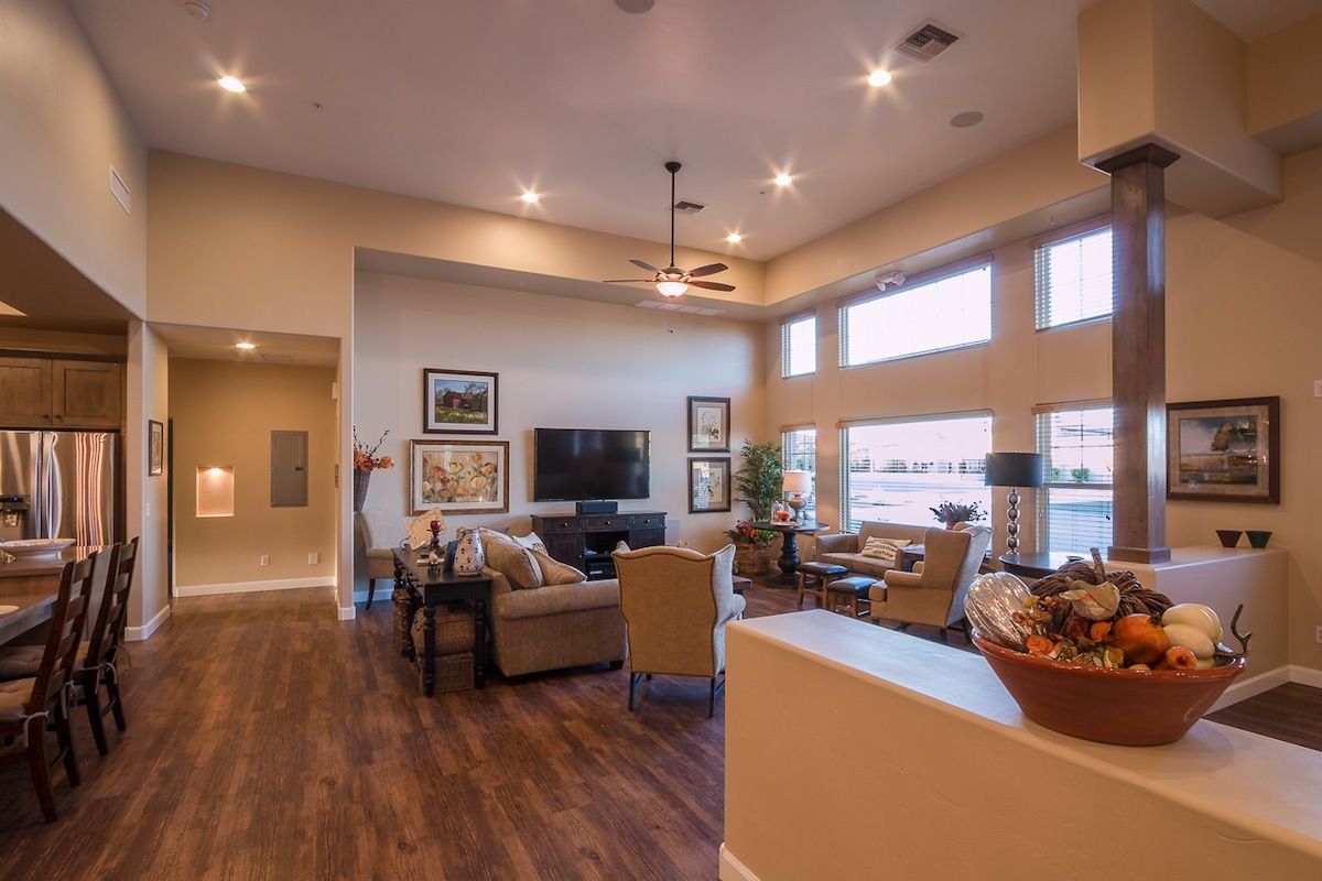 A modern and spacious living room with cozy furniture and warm lighting.