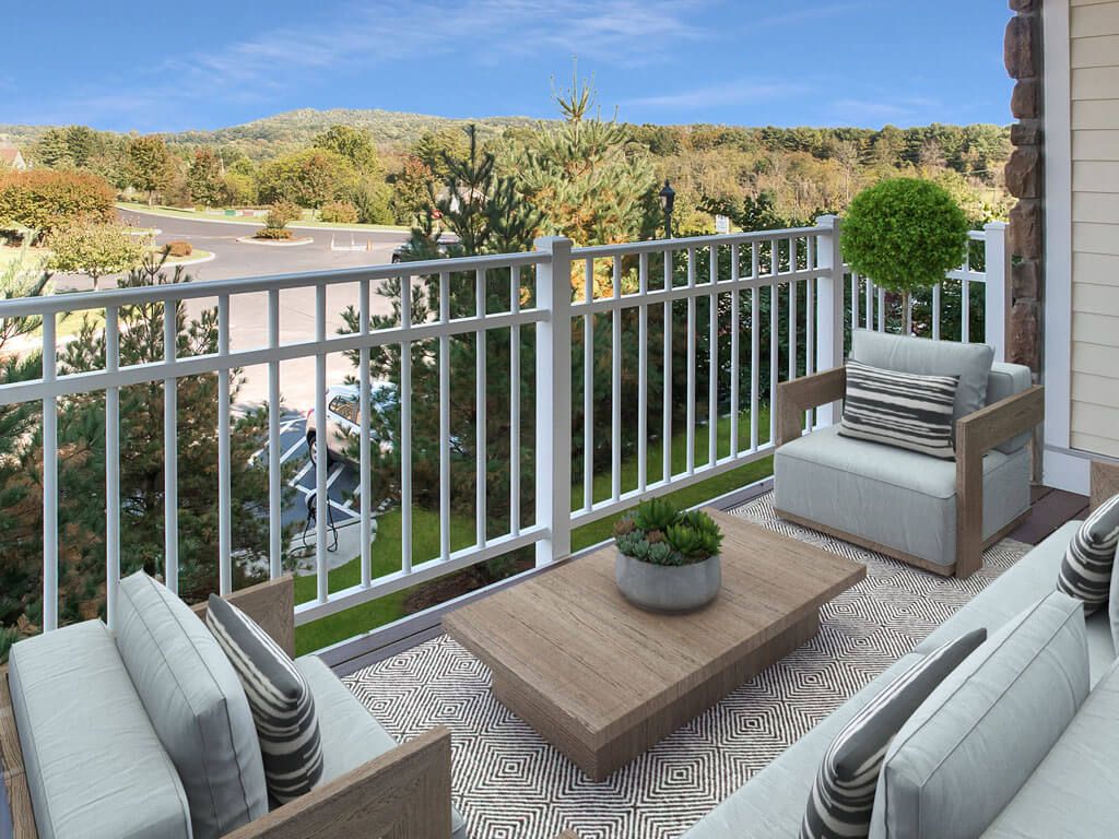 A cozy balcony with comfortable seating and a scenic nature view.