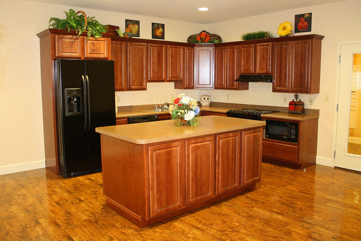A modern kitchen featuring wooden cabinets, a central island, and appliances.