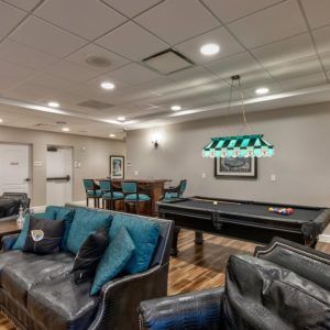 A modern game room featuring a pool table and comfortable seating.
