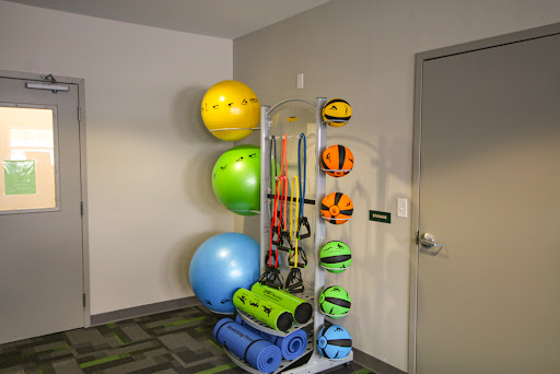 A well-organized display of various fitness equipment including balance balls, yoga mats, and resistance bands.