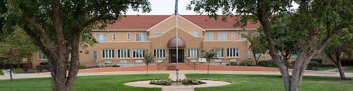 A modern brick building featuring an elegant entrance and well-maintained landscaping.