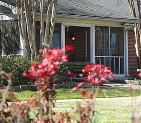 A charming residential home with a welcoming front porch framed by vibrant flowers.