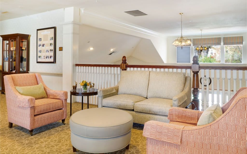 A cozy living room featuring a sofa, armchairs, and a coffee table with elegant interior decor.