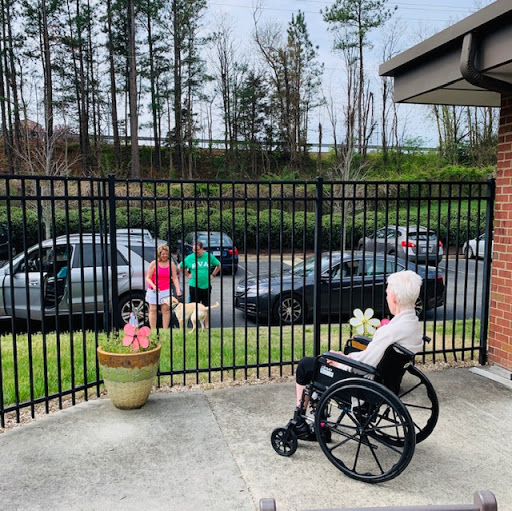 An elderly person in a wheelchair enjoys the view while children play nearby.