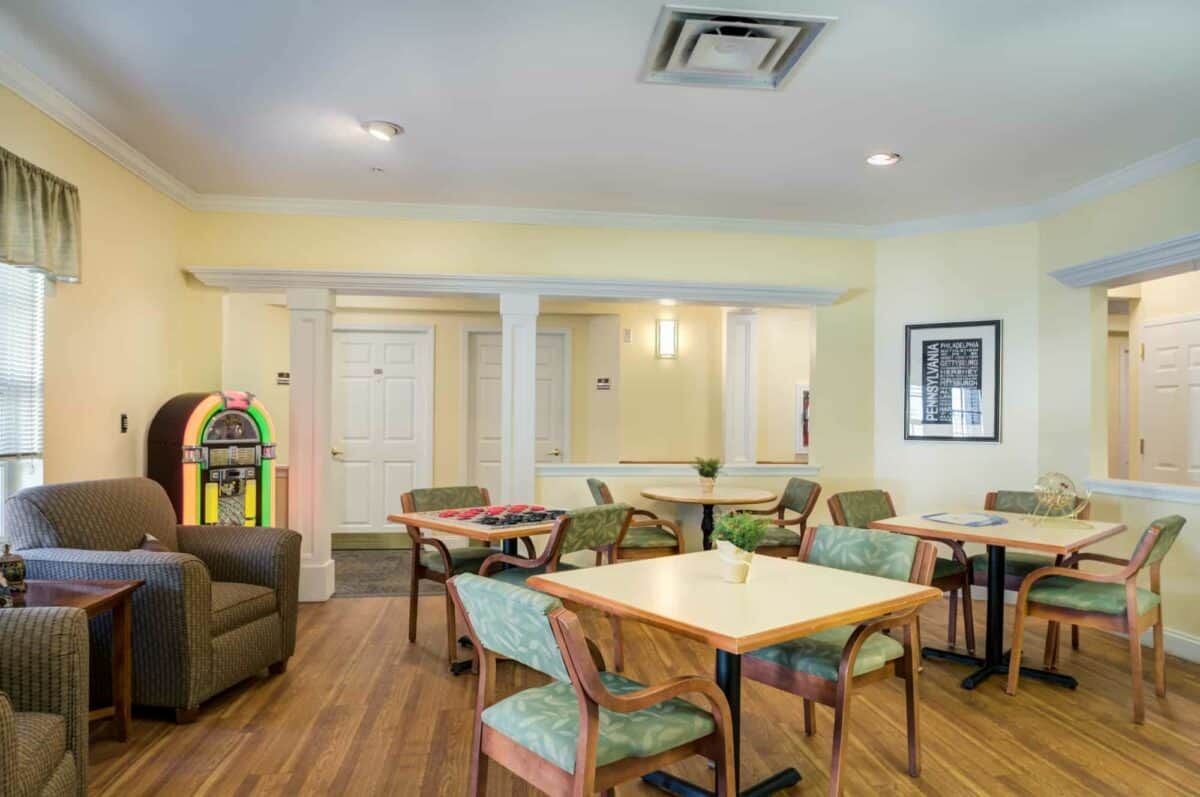 A cozy communal dining area with tables and chairs, featuring a modern design.