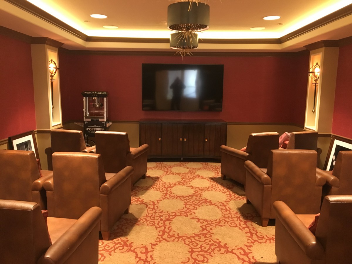 A cozy home theater room with comfortable armchairs facing a large screen.