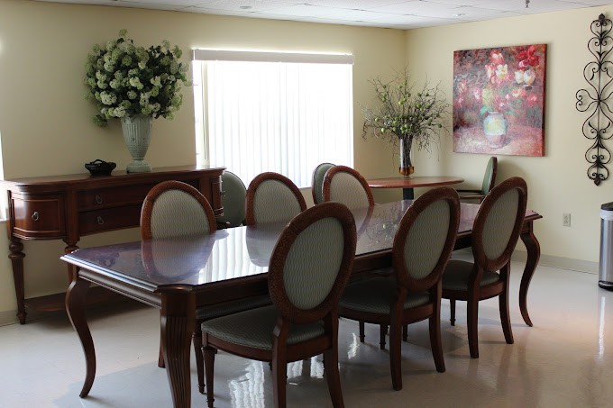 Elegant dining room with a large table, chairs, and floral decorations.
