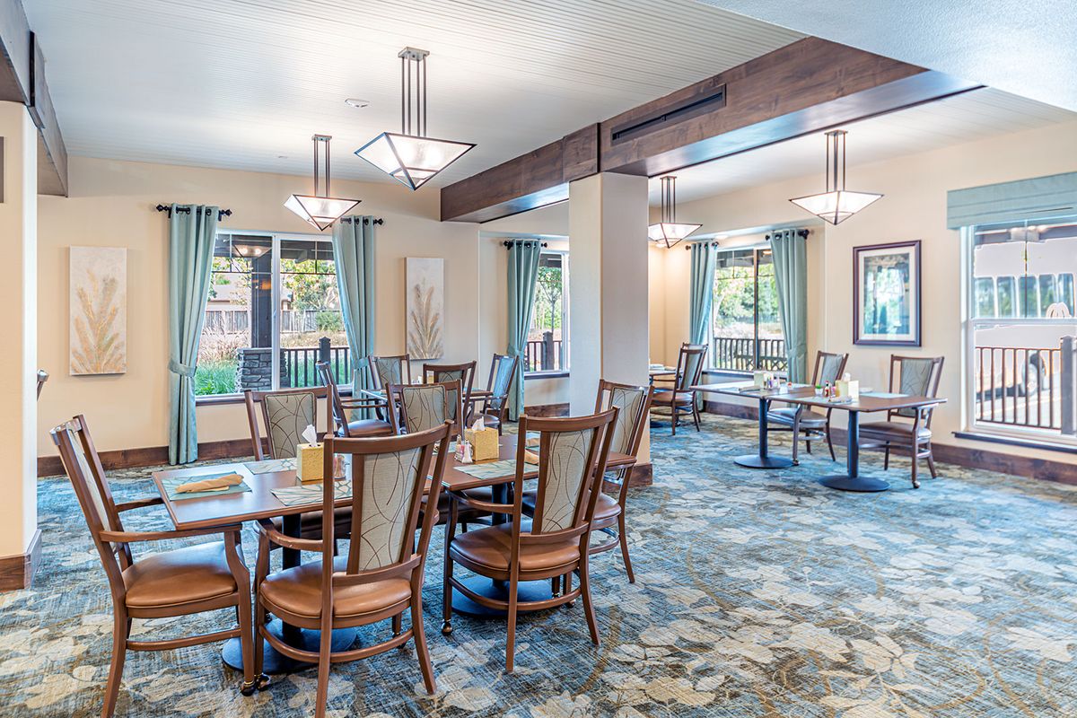 A well-lit dining area with multiple tables and chairs arranged neatly.