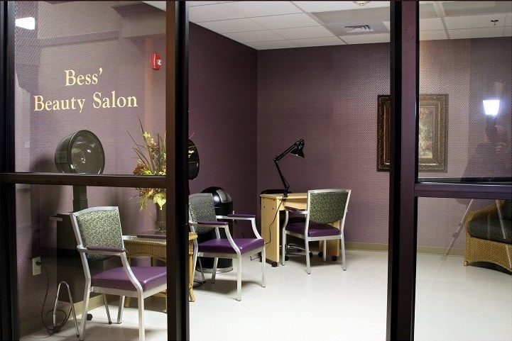 An interior view of a quiet nail salon with chairs and a desk.