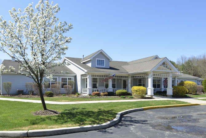 A suburban residential house with a driveway and landscaped yard.