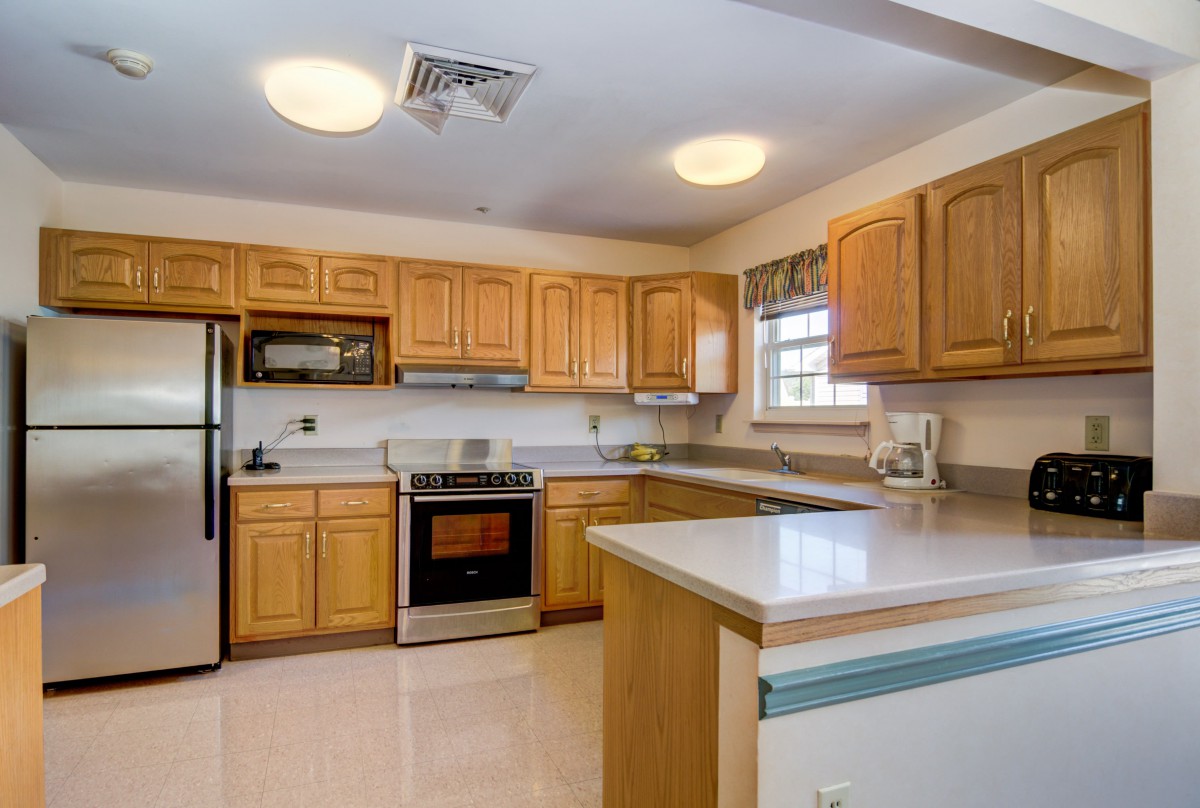 A spacious kitchen with wooden cabinets and stainless steel appliances.