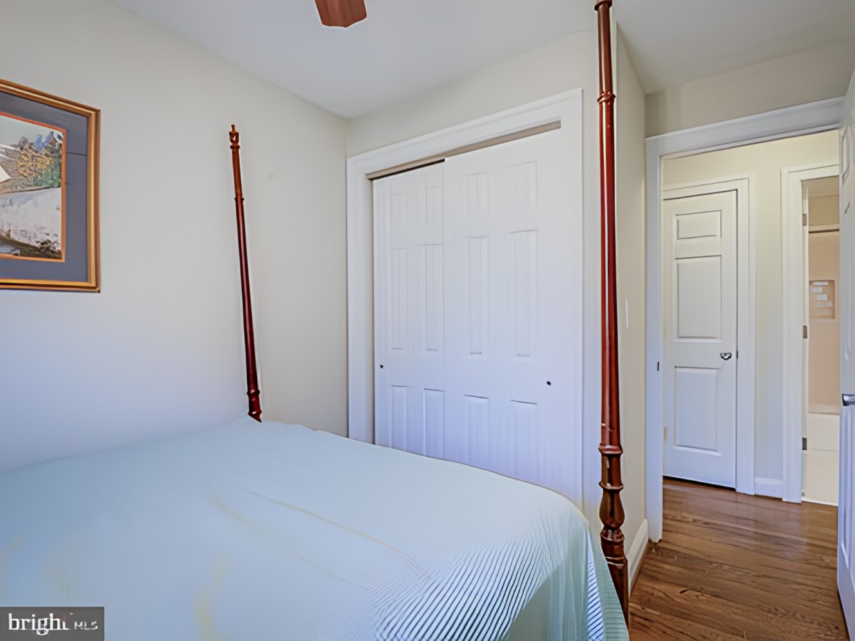 A cozy bedroom featuring a four-poster bed and a closed closet door.