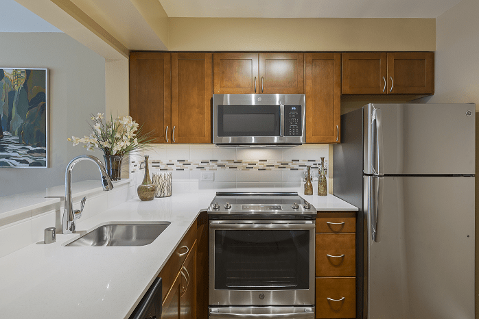 A modern kitchen with stainless steel appliances and wooden cabinets.