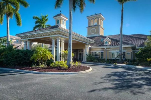 A tropical-style building with palm trees and a welcoming entrance.