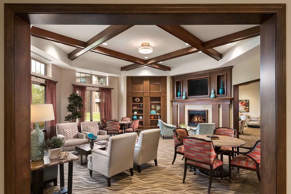 A cozy and elegantly designed living room featuring comfortable seating, a fireplace, and warm lighting.