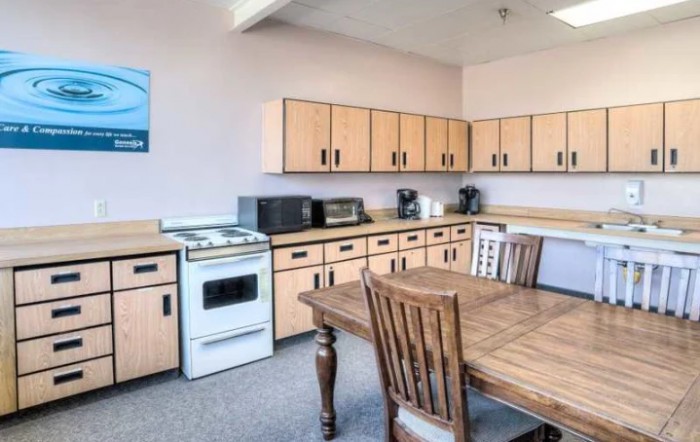 A cozy kitchen with wooden cabinets, a dining table, and appliances.