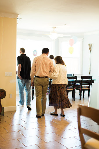A group of individuals walking together in a bright, airy room.