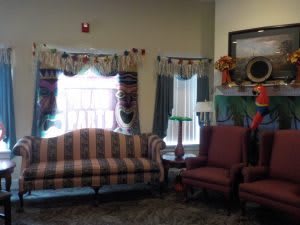A cozy living room with striped couch, armchairs, and decorative curtains by the windows.