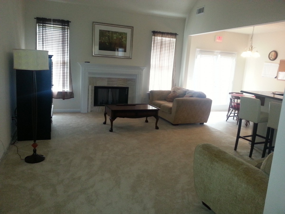 A spacious living room with a fireplace and comfortable seating.