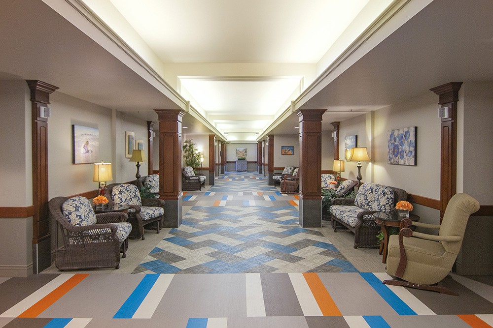 A spacious hallway with patterned flooring and comfortable seating areas.