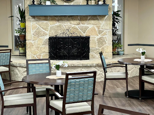 A cozy dining area featuring a stone fireplace and modern furniture.